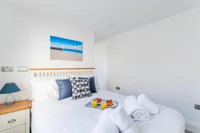 a white bed with towels and fruit on it at Marcella's Retreat in St Ives