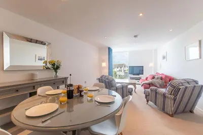 a living room with a table and chairs at Wingtips in Carbis Bay
