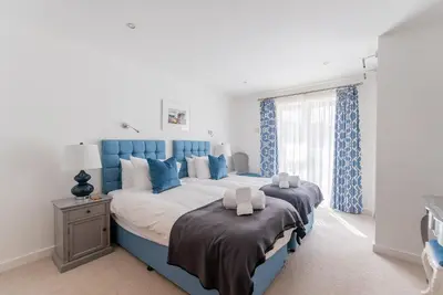a blue and white bedroom with a large bed at Wingtips in Carbis Bay