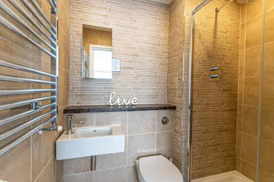a bathroom with a sink and a toilet and a shower at Wingtips in Carbis Bay
