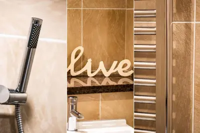 a bathroom with a sink and a sign that says live at Wingtips in Carbis Bay