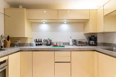 a kitchen with yellow cabinets and a counter top at Wingtips in Carbis Bay