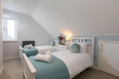 a bedroom with two beds with blue and white at Chi Lowen in Carbis Bay