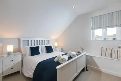 a bedroom with a bed with towels on it at Chi Lowen in Carbis Bay