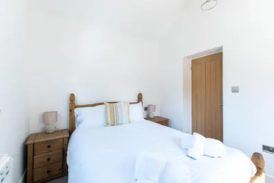 a bedroom with a large white bed with towels on it at Beached Az in St Ives