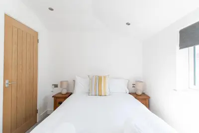 a bedroom with a white bed and a window at Beached Az in St Ives