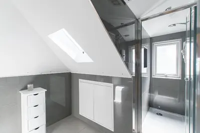 a bathroom with a white cabinet and a skylight at Beached Az in St Ives