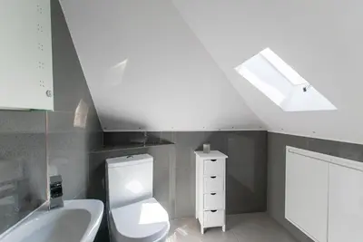 a bathroom with a toilet and a sink and a skylight at Beached Az in St Ives