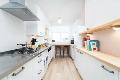 a kitchen with white cabinets and a stove top oven at Mavericks in St Ives