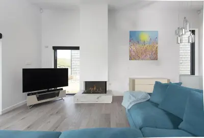 a living room with a blue couch and a fireplace at The Shore in Mawgan Porth