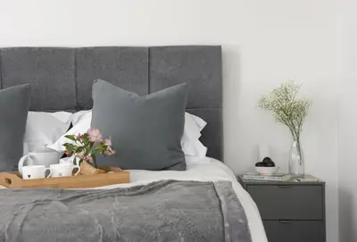a bed with a tray with flowers and mugs on it at The Shore in Mawgan Porth