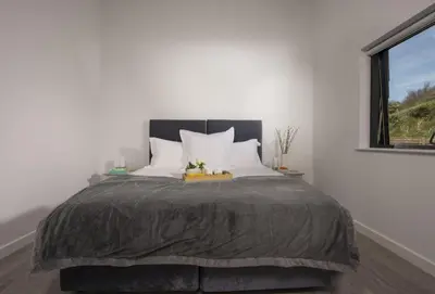 a bedroom with a large bed and a window at The Shore in Mawgan Porth