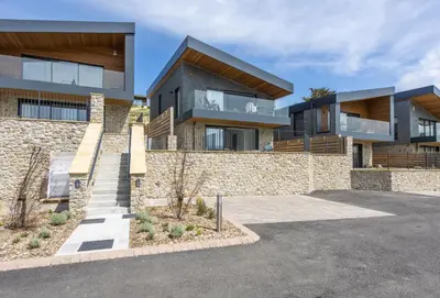 a house with a stone wall at The Shore in Mawgan Porth