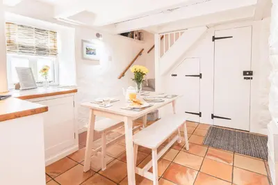 a kitchen with a table and chairs in a room at Salty's Cottage in St. Agnes