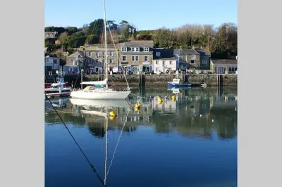 a boat is docked in a harbor with houses at Large 5 bed 3 bath house 300 meters from beach and restaurants in Newquay