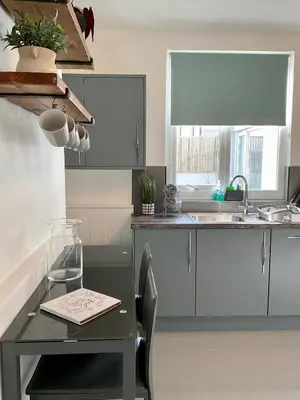 a kitchen with a table and a sink at Large 5 bed 3 bath house 300 meters from beach and restaurants in Newquay