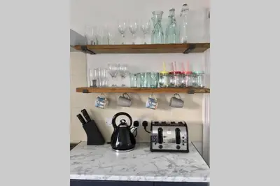 a kitchen counter with a tea kettle and glasses at Large 5 bed 3 bath house 300 meters from beach and restaurants in Newquay