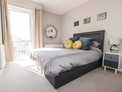 a bedroom with a bed with two yellow pillows at 23 Tre Lowen in Newquay