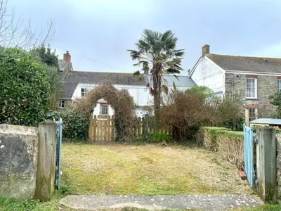 a house with a gate and a palm tree at Mapa Cottage in Mount Hawke