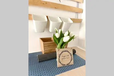 a vase with white flowers sitting on a blue rug at Luna Beach - Luxury Carbis Bay Apartment + Parking in Carbis Bay