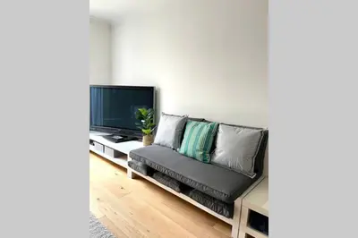 a living room with a couch and a flat screen tv at Luna Beach - Luxury Carbis Bay Apartment + Parking in Carbis Bay