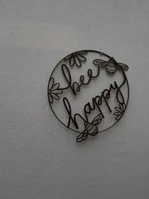 a sign on a wall with the word happy at Rose Cottage Bee Happy anex in Newquay
