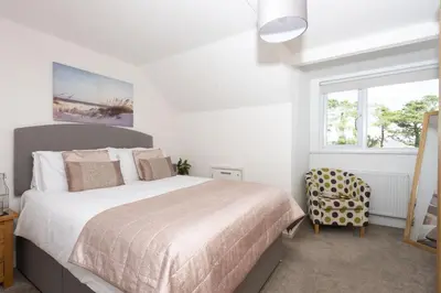 a bedroom with a large bed and a window at Bridge Apartment - Free Parking & WiFi - Near Perranporth Beach in Perranporth