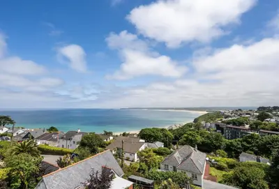 a view of a coastal town with houses and the ocean at 8 Fernhill in Carbis Bay