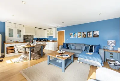 a living room with a couch and a kitchen at 8 Fernhill in Carbis Bay