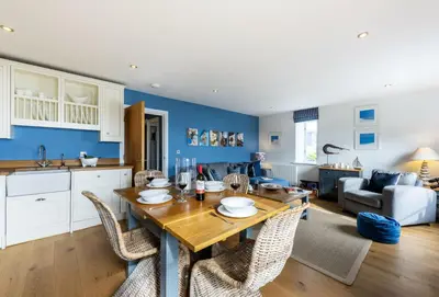 a kitchen and living room with a wooden table and chairs at 8 Fernhill in Carbis Bay