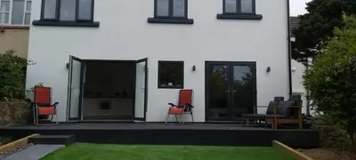 a house with chairs sitting on a patio at Newquay Rialton Holiday Home in Newquay