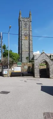 a stone building with a clock tower on a street at Newquay Rialton Holiday Home in Newquay