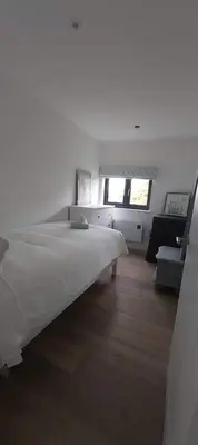a white bedroom with a bed and a couch at Newquay Rialton Holiday Home in Newquay