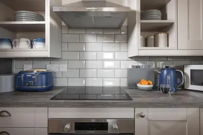 a kitchen with a counter top with a blue appliance at Greenfields Coach House - Balcony with stunning ocean view in Marazion