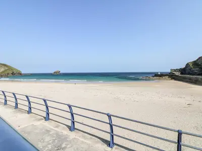 a blue railing on a beach with the ocean at Summerhayes in Redruth