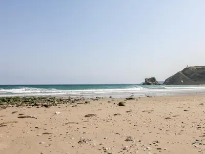 a sandy beach with rocks in the ocean at Summerhayes in Redruth