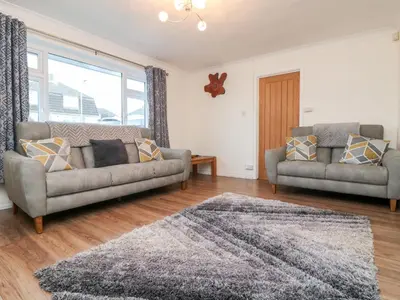 a living room with two couches and a rug at Summerhayes in Redruth