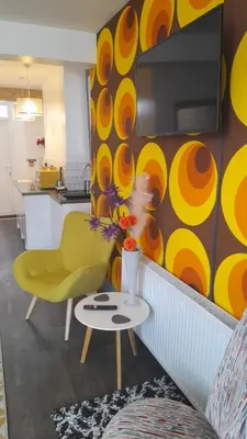 a living room with a yellow chair and a table at Sandy Toes Accommodation in Par