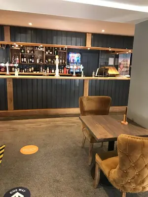 a bar with chairs and a wooden table and a counter at Bude 13 in Cubert