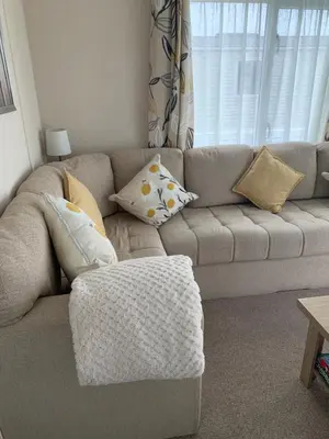 a living room with a gray couch with pillows at Bude 13 in Cubert