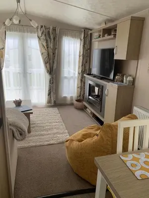 a living room with a couch and a television at Bude 13 in Cubert