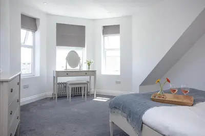 a bedroom with a bed and a dressing table and a mirror at Ocean View, Newquay - Free WiFi & Parking - Sea Views in Newquay