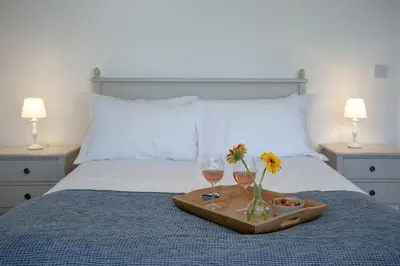 a tray with two glasses of wine and flowers on a bed at Ocean View, Newquay - Free WiFi & Parking - Sea Views in Newquay