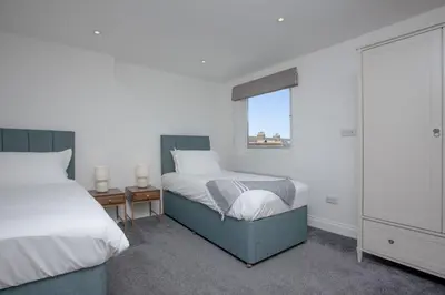 a bedroom with two beds and a window at Ocean View, Newquay - Free WiFi & Parking - Sea Views in Newquay