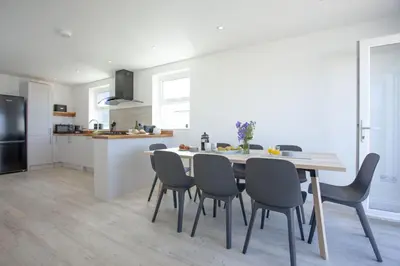 a kitchen and dining room with a table and chairs at Ocean View, Newquay - Free WiFi & Parking - Sea Views in Newquay