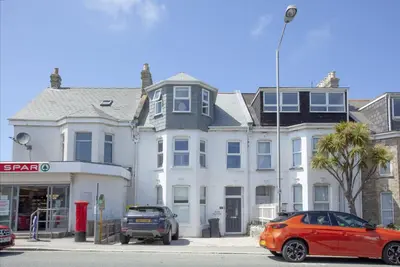 a red car parked in front of a white house at Ocean View, Newquay - Free WiFi & Parking - Sea Views in Newquay