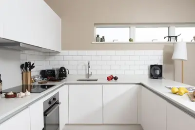 a white kitchen with white cabinets and appliances at Salt Life, Dunes at Upton Towans - Hot tub - Pet friendly - Self check in in Hayle