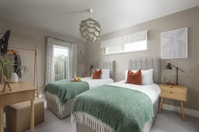 a bedroom with two beds with green and white sheets at Salt Life, Dunes at Upton Towans - Hot tub - Pet friendly - Self check in in Hayle
