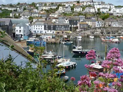 a harbor with boats in the water and a town at Rose Cottage in St Austell