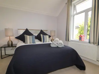 a bedroom with a large bed with shoes on it at Robin Hill in St Austell